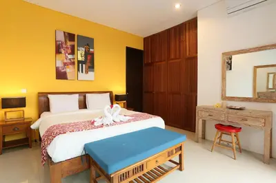 a bedroom with a bed and a table and a mirror at Villa Stephana Edge of Seminyak in Canggu
