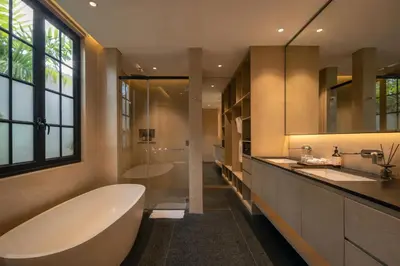 a bathroom with a tub and two sinks and a window at Marvee Villa Bali in Canggu