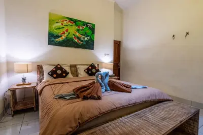 a bedroom with a bed and a painting on the wall at Just a 3 min stroll to the Seminyak beach in Badung