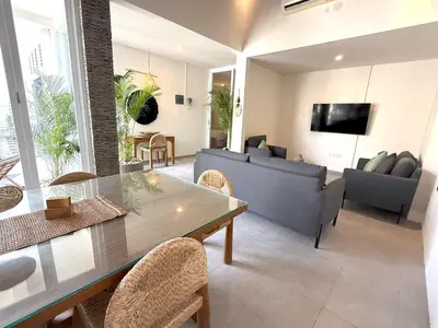 a living room with a table and a couch at Villa KAS Legian Seminyak - 6 Bedroom Villa in Seminyak