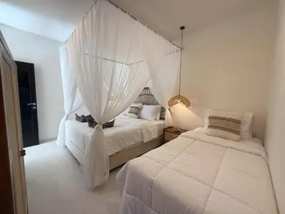 a bedroom with two beds with mosquito nets at Villa KAS Legian Seminyak - 6 Bedroom Villa in Seminyak