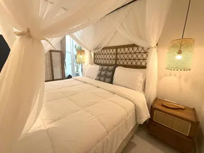 a bedroom with a white bed with a canopy at Villa KAS Legian Seminyak - 6 Bedroom Villa in Seminyak