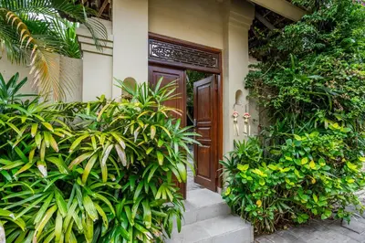 a front door of a house with green plants at 3-Bedroom Villa near Kudeta Beach - Oberoi Street By iBali Management in Seminyak