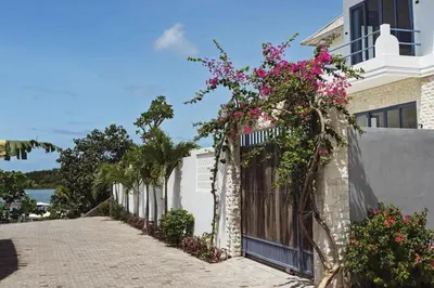 a house with flowers on the side of it at Stunning Sea Front Villa 4BR Nusa Dua in Badung