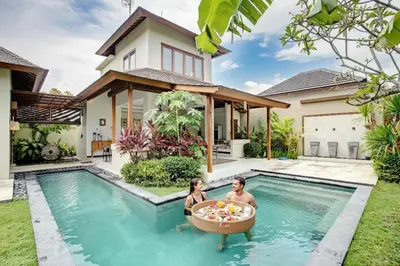 a man and woman in a bath tub in a swimming pool in a house at Villa Shanti, Sitara Villa Group in Seminyak