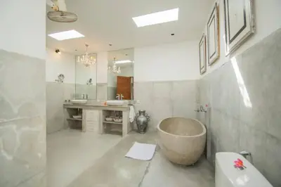 a bathroom with a large tub and a sink at Villa Shanti, Sitara Villa Group in Seminyak