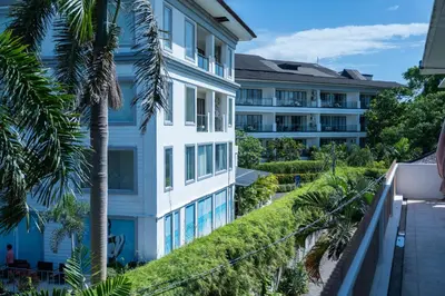 an apartment building with vegetation on the side of it at 5BR Private Pool Villa - 1 min Beach - Daily Staff, Private Pool, Gym & Games in Canggu