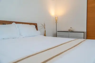 a bedroom with a white bed and a lamp at 5BR Private Pool Villa - 1 min Beach - Daily Staff, Private Pool, Gym & Games in Canggu