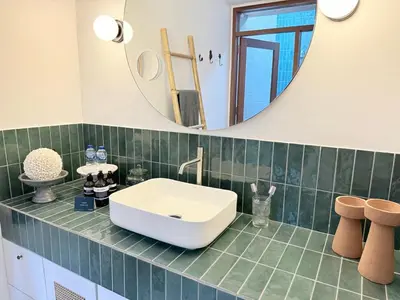 a bathroom with a white sink and a mirror at Villa Gamelan Bohème Chic Bali in Seminyak