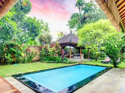 an image of a swimming pool in a garden at Villa Taman Rahasia, Sitara Villa Group in Seminyak