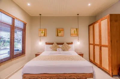 a bedroom with a large bed and a window at Villa Taman Rahasia, Sitara Villa Group in Seminyak