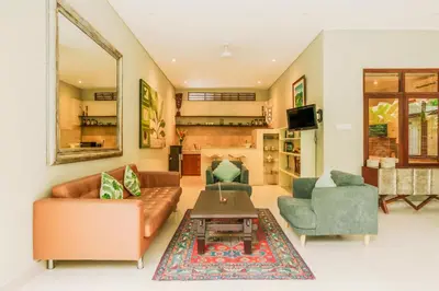 a living room with a couch and two chairs and a table at Villa Taman Rahasia, Sitara Villa Group in Seminyak