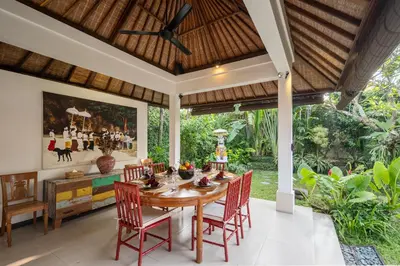 an outdoor dining room with a wooden table and chairs at Tropical Oasis of Calm in the Heart of Seminyak, 4BR Villa Luisha in Seminyak