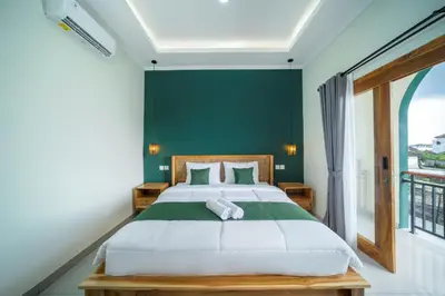 a bedroom with a large bed with a green wall at D'Gangga Residence By Bali Cabin in Kerobokan