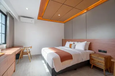 a bedroom with a large bed with a desk and a desk at Villa Loema in Kerobokan