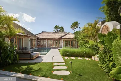 an exterior view of a house with a garden at Villa Massilia Bali in Seminyak