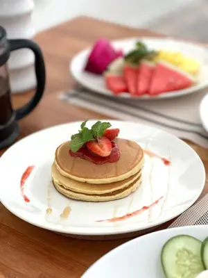 a stack of pancakes on a plate on a table at Villa Sitara, Sitara Villa Group in Seminyak