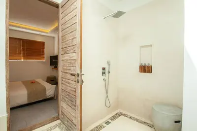 a bathroom with a shower and a toilet and a bed at Modern 4bd villa, amazing location in Seminyak in Seminyak