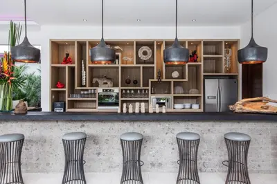 a kitchen with a bar with four stools at Seminyak Luxueuse villa 61 BR 18 personnes in Seminyak