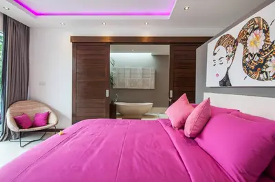 a large pink bed in a bedroom with a bathroom at Seminyak Luxueuse villa 61 BR 18 personnes in Seminyak