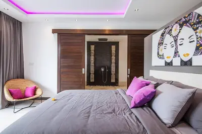 a bedroom with a large bed with purple pillows at Seminyak Luxueuse villa 61 BR 18 personnes in Seminyak