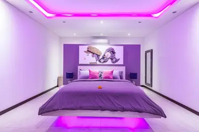 a bedroom with a purple bed with pink lights at Seminyak Luxueuse villa 61 BR 18 personnes in Seminyak