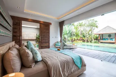 a bedroom with a large bed and a pool at Seminyak Luxueuse villa 2 chambres in Seminyak