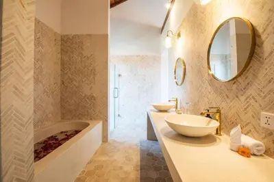 a bathroom with two sinks and a tub and a mirror at Luxurious 5 bd villa in Seminyak - art deco style in Canggu