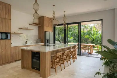 an open kitchen with a large island with bar stools at Luxurious 5 bd villa in Seminyak - art deco style in Canggu