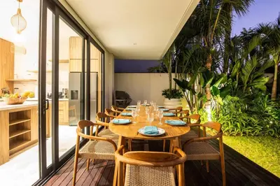 a dining room with a wooden table and chairs at Luxurious 5 bd villa in Seminyak - art deco style in Canggu