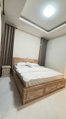 a bedroom with a wooden bed in a room at Graha Shanti Guest House in Pulau Serangan