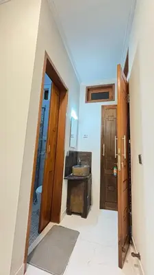 a bathroom with a sink and a wooden door at Graha Shanti Guest House in Pulau Serangan