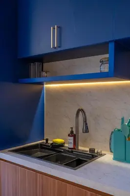 a kitchen with a sink and blue cabinets at 1BR Modern Loft near Airport in Pesanggaran