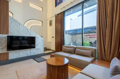 a living room with a couch and a large window at 2BR Modern Suites near Airport in Pesanggaran