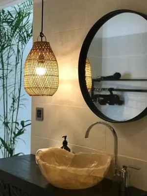 a bathroom with a stone sink and a mirror at Villa Casa Mari in Seminyak