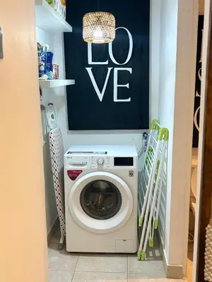 a washing machine in a laundry room with a sign at Villa Casa Mari in Seminyak