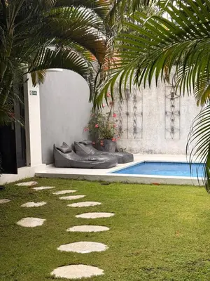 a house with a swimming pool and a palm tree at Villa Casa Mari in Seminyak