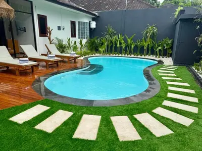 a swimming pool in a yard with green grass at Villa AYLA - Legian - 5 Bedrooms - 5 Bathrooms in Seminyak