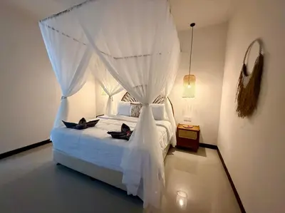a bedroom with a white bed with a canopy at Villa AYLA - Legian - 5 Bedrooms - 5 Bathrooms in Seminyak