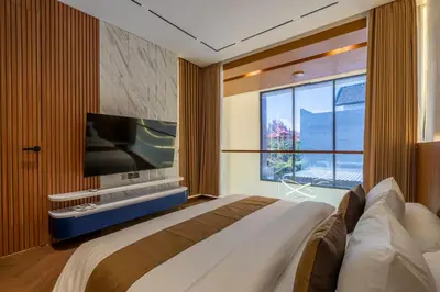 a bedroom with a large bed and a flat screen tv at 1BR Stylish Loft near airport in Pesanggaran