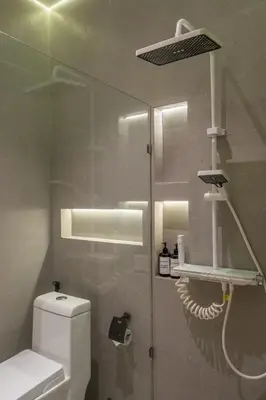 a bathroom with a toilet and a glass wall at 1BR Stylish Loft near airport in Pesanggaran