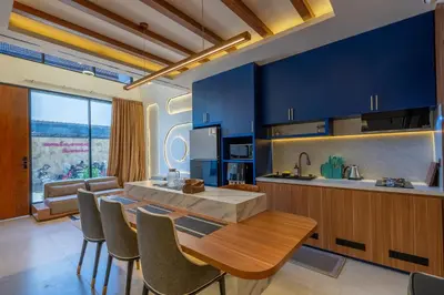 a kitchen with blue cabinets and a table and chairs at 1BR Stylish Loft near airport in Pesanggaran