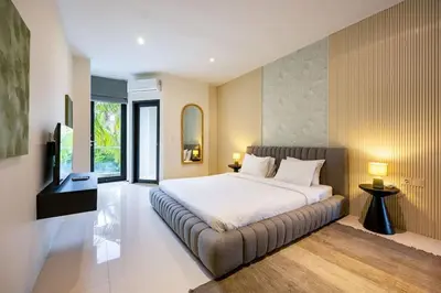a bedroom with a large bed with a couch at Damai Suite Relax & Comfort in Canggu 3BR in Canggu