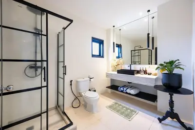 a bathroom with a toilet and a sink and a shower at Damai Suite Relax & Comfort in Canggu 3BR in Canggu