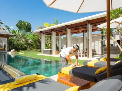 a man standing in front of a swimming pool at Villa Lilibel by Elite Havens in Seminyak