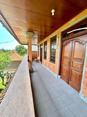a porch of a house with a wooden door at Nyoman Legian House in Legian