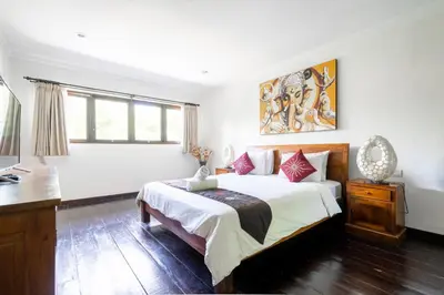 a bedroom with a bed and a desk and window at Villa Vista 2 Seminyak in Seminyak