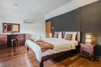 a bedroom with a large bed and a wooden floor at Villa Vista 3 Seminyak in Seminyak