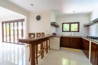 a large kitchen with a wooden island in the middle at 9 Bedroom Villa Vista Seminyak in Seminyak