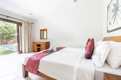 a bedroom with a large white bed with pillows at 9 Bedroom Villa Vista Seminyak in Seminyak